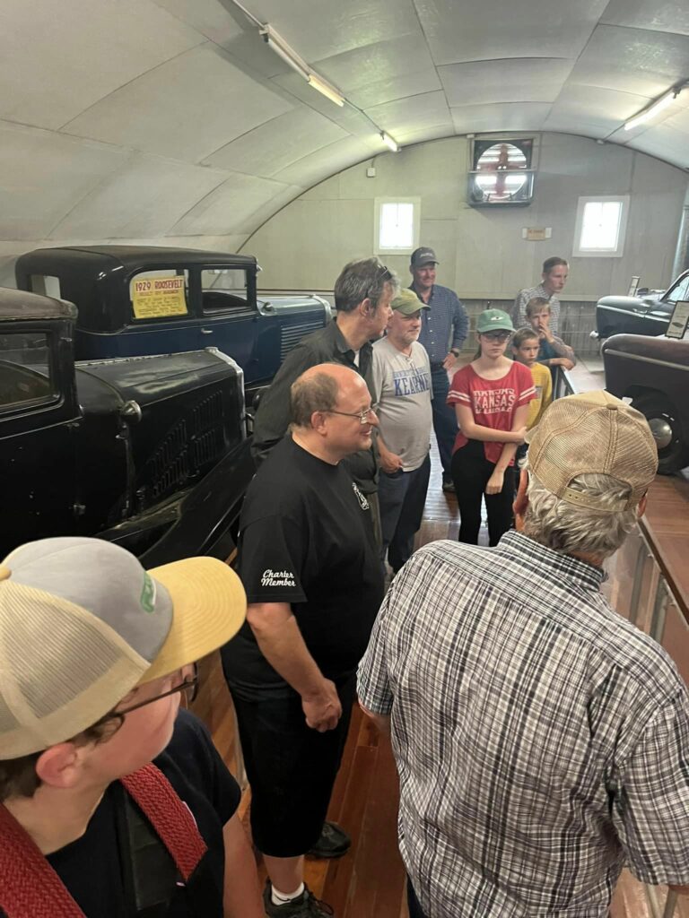 Members of the JCT 6/10 Cruzerz Car Club looking at the car collection in Pioneer Village.