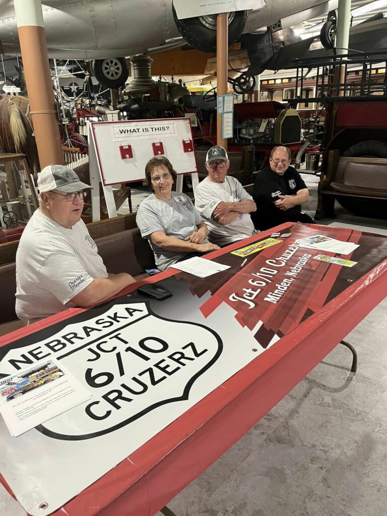 Group of JCT 6/10 Cruzerz members sitting at a booth at Pioneer Village.